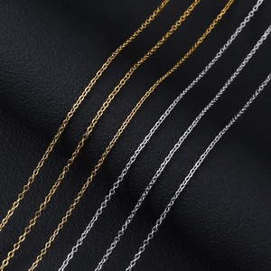 Close-up of gold and silver stainless steel cross chains on black leather texture