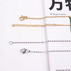 Close-up of gold and silver stainless steel cross chains with lobster clasps and extension links