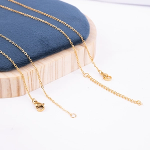 Detail of golden stainless steel cross chain with lobster clasp and extension chain