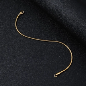 Detailansicht einer goldenen Schlangenkette mit Karabinerverschluss auf Leder
