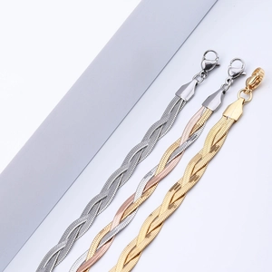 Detailed view of woven herringbone chains in silver, gold and rose gold mixed tones