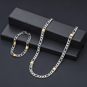 Juego de collar y pulsera Figaro en plata y oro pulido sobre joyero de color negro