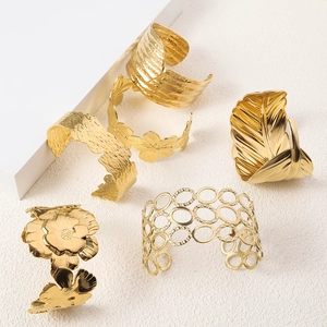 Detail shot of 18K gold plated stainless steel bangles with floral and leaf embossing