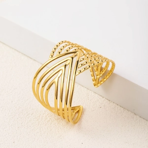 Detail of 18K gold-plated stainless steel cuff with geometric layered lines and textures