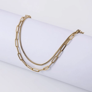 Detail of gold double-layered bracelet with paperclip links and delicate box chain style