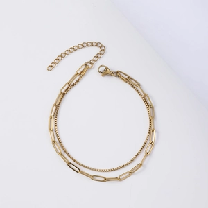 Detail of golden double-layer paperclip and box chain bracelet with lobster clasp