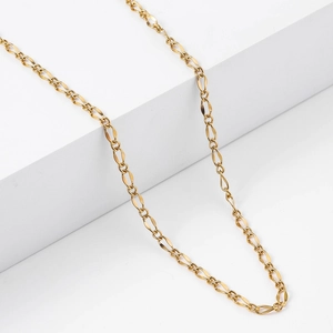 Minimalist 18k gold plated stainless steel lip chain necklace shown on a geometric stand