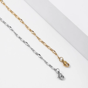 Detailed macro view of gold and silver stainless steel twisted lip chain necklaces with lobster clasps