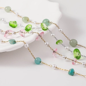 Mixed semi-precious stone and pearl DIY jewelry chains on white ceramic tray