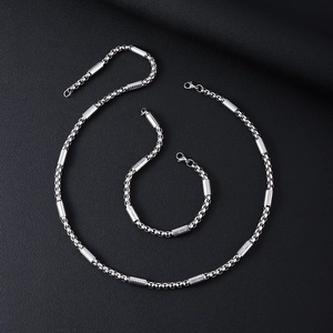 Polished stainless steel necklace and bracelet set with cylindrical tube links on leather