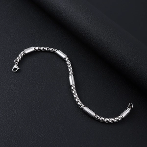 Macro shot of silver stainless steel box chain necklace with striped metal beads and clasp