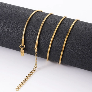 Detail van 18K vergulde achthoekige slangenketting met karabijnsluiting op zwarte houder