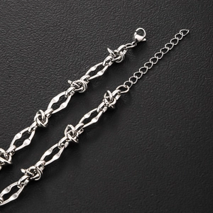 Poliertes Edelstahl-Armband im Stacheldraht-Stil mit Karabinerverschluss auf schwarzem Leder