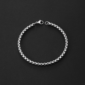 Close-up of polished silver stainless steel box chain bracelet with lobster clasp detail