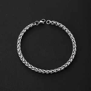 Detailed view of silver wheat chain texture and secure lobster clasp on black leather