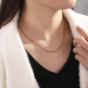 Halskette aus 18K vergoldetem Edelstahl mit Perlenkette, getragen von Model auf Kleidung