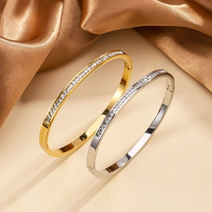 Dettaglio di bracciali a cerniera in oro e argento con zirconi quadrati incastonati