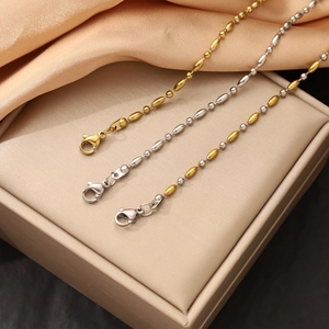 Detailansicht von 18K Gold- und Silberkugelketten auf Satin-Schmuckkästchen-Hintergrund