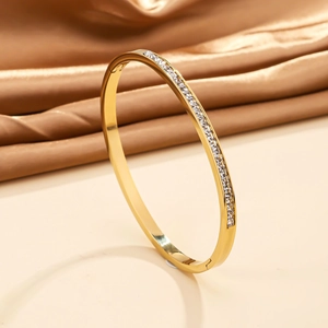 Dettaglio del bracciale in acciaio dorato 18 carati con zirconi lucidi su seta