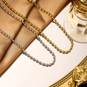 Polished 18K gold and silver stainless steel bead chain necklaces on silk background