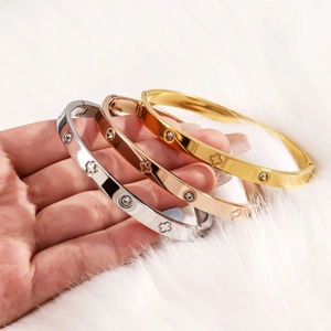 Three-piece stainless steel clover bangle set in gold, silver, and rose gold finishes