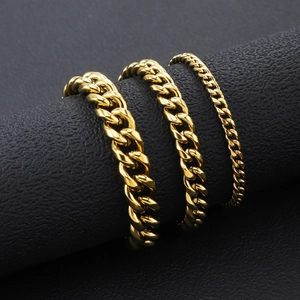 Three sizes of 18K gold plated stainless steel Cuban link chains on a black display stand