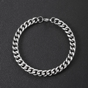 Detailed close-up of a polished silver stainless steel Cuban link bracelet with lobster clasp