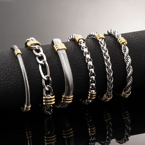 Set of six stainless steel bracelets with silver and gold tones on a black display