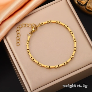Macro detail of gold-plated stainless steel box chain bracelet with lobster clasp and extender