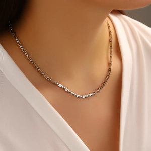 Macro detail of minimalist polished stainless steel box chain necklace on skin