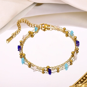 Detail of three-layer gold chain bracelet with colorful natural stones on mirror