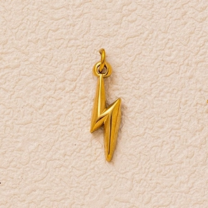 Detailed view of a gold lightning bolt charm with sharp 3D edges and polished metal finish