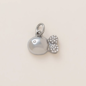 Macro detail of a silver fish pendant with sparkling rhinestones for DIY jewelry making