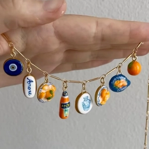 Gold Mediterranean charm bracelet with evil eye and orange pendants on a fine chain