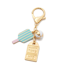 Detail of gold keychain with colorful popsicle charm and engraved Hamptons metal tag