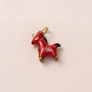 Détail d'un pendentif cheval rouge peint à la main avec motifs floraux et bélière dorée