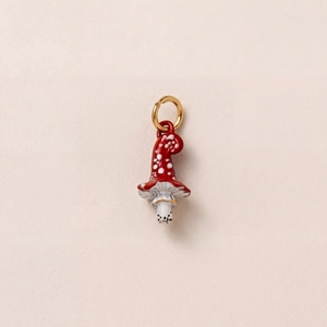 Détail d'un pendentif champignon en or 18 carats avec émail rouge et pois blancs