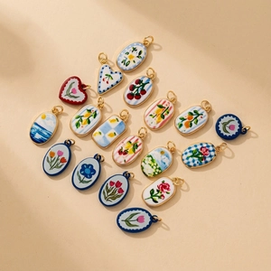 Detailed view of assorted ceramic charms with hand-painted floral and fruit designs