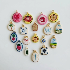 Vue à plat de pendentifs en céramique avec des illustrations de fruits et d'insectes colorés