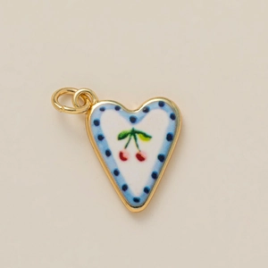 Golden heart pendant featuring red cherry pattern and blue polka dot enamel finish