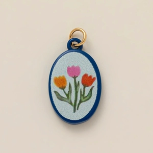 Gold-plated oval pendant with blue enamel and colorful tulip flower illustration