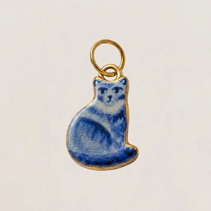 Detailansicht des katzenförmigen blauen Keramikanhängers mit Goldrand und floralem Muster