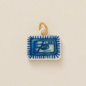 Colgante rectangular de cerámica blanca con motivos azules y anillo de metal dorado