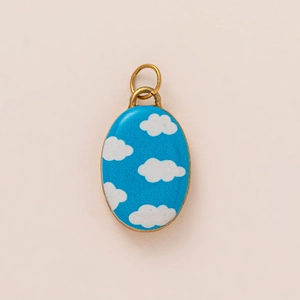 Oval sky blue cloud pendant with 18K gold plating on a minimalist cream background