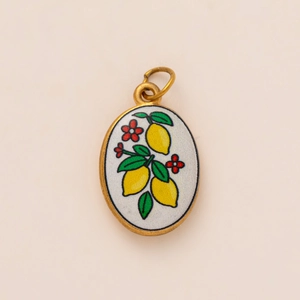 Oval gold pendant with hand-painted yellow lemons and small flowers on a white base