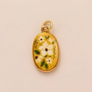 Oval gold-plated enamel pendant with white floral design and green leaves for DIY jewelry