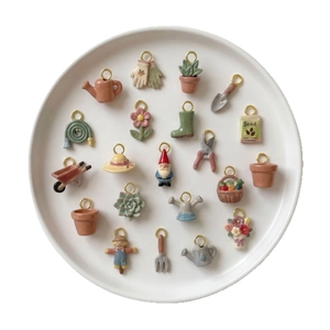 Set de 20 colgantes de jardín con regadera y guantes sobre un plato blanco