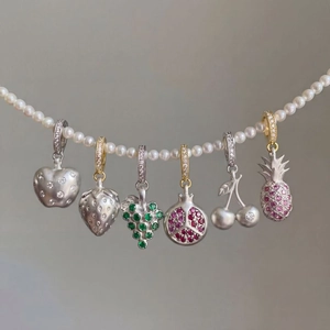 Creative fruit-themed zircon pendants including apple and strawberry on a pearl necklace