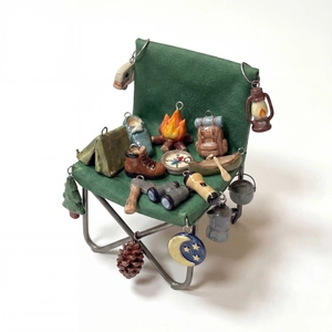 Detailed view of colorful camping themed charms including binoculars and tents on a mini chair