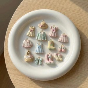 Detailaufnahme bunter Harz-Anhänger mit Kleid- und Stiefelmotiven für DIY-Schmuck